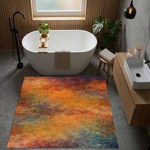 May include: A rectangular floor mat featuring an abstract, textured pattern with vibrant blends of orange, red, yellow, and deep blue tones. The surface displays a mottled, painterly effect with varied color intensity across the entire area.