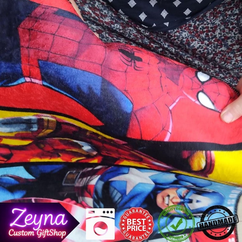 May include: A colorful blanket featuring illustrations of Marvel superheroes, including Spider-Man and Captain America. The blanket has a red, blue, and yellow color scheme. The text "Zeyna Custom GiftShop" is visible in the corner.