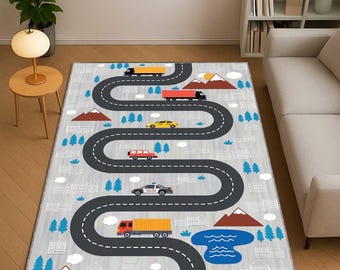 May include: A gray children's play rug featuring a winding road design with toy cars, trucks, and a police car. The rug includes illustrations of mountains, trees, and a lake, creating a playful town scene.