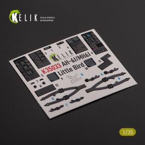 May include: A sheet of scale model accessories for the AH-6J/MH6J Little Bird helicopter. The sheet includes various detailed parts, such as instrument panels, seatbelts, and other small components. The sheet is labeled with the KELIK brand and the scale is 1/35.