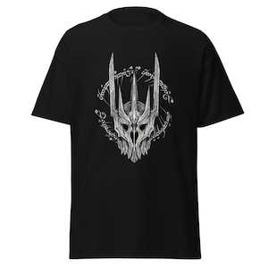 May include: Black t-shirt featuring a detailed white graphic of a skeletal crown with pointed tips and an encircling inscription. The design is centered on the front of the shirt, offering a striking contrast against the dark fabric. A classic crew neck design.