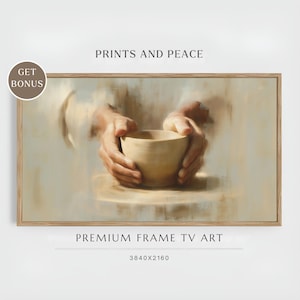 May include: A framed print featuring a neutral-toned painting of hands cradling a light-colored bowl. The artwork is set against a soft, blurred background. The text "PRINTS AND PEACE" and "PREMIUM FRAME TV ART" are displayed on the image.