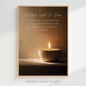 Puede incluir: Impresión enmarcada con un tono sepia cálido, que representa una vela encendida en un cuenco. La obra de arte incluye el texto "Let Your Light So Shine" y un versículo bíblico. Las palabras "PRINTS AND PEACE" están abajo.
