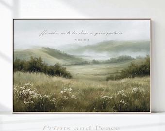 May include: A rectangular landscape wall art print featuring a misty, rolling green meadow with tall grasses and white wildflowers in the foreground. The text "He makes me to lie down in green pastures" and "Psalm 23:2" is printed in black script and serif font.