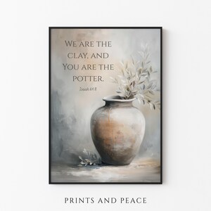 Puede incluir: Una impresión artística enmarcada con un jarrón de tonos neutros con ramas frondosas. La obra de arte incluye el texto "WE ARE THE CLAY, AND YOU ARE THE POTTER. Isaiah 64:8" y las palabras "PRINTS AND PEACE" en la parte inferior.