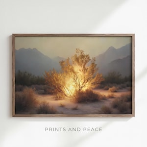 May include: A framed landscape print depicting a desert scene with a radiant bush at its heart. The artwork uses a warm colour palette of gold, brown, and beige. Mountains are visible in the background. The text "PRINTS AND PEACE" is at the bottom.