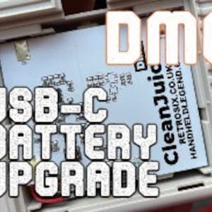 May include: Close-up of a Game Boy Color with a USB-C battery upgrade. The words "USB-C BATTERY UPGRADE" are printed in white on a black background. The words "DMG" are printed in white on a red background. The words "cleanjuice" are printed in white on a blue background.