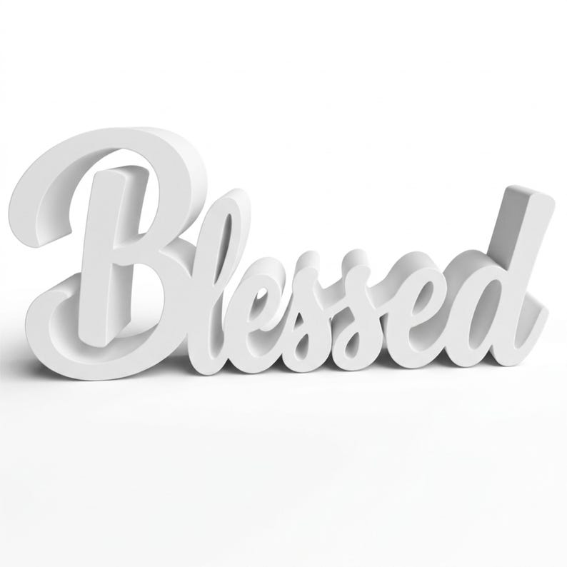 Puede incluir: Un letrero blanco tridimensional que deletrea la palabra "Blessed" en cursiva. El letrero est&aacute; hecho de un material s&oacute;lido y est&aacute; sobre un fondo blanco. Las letras est&aacute;n claramente definidas.