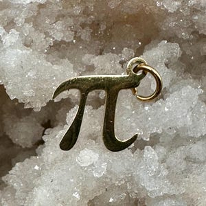 以下が含まれることがあります： 数学記号のパイの形をした金色のチャーム。チャームの上部にネックレスやブレスレットに取り付けるためのループがあります。