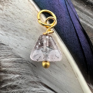 May include: A gold charm with a clear, pink, and silver glass bead in the shape of a triangle. The charm is attached to a gold ring.