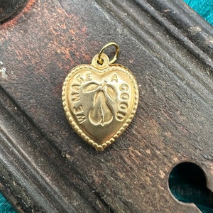 May include: Gold heart-shaped charm with a pear design and the text "We make a good team".