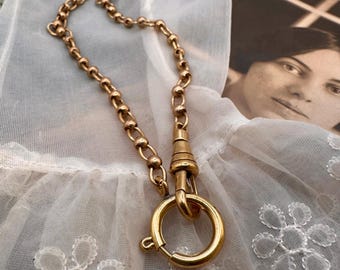 Puede incluir: Un collar de cadena de oro con un cierre redondo. La cadena está hecha de pequeños eslabones redondos.
