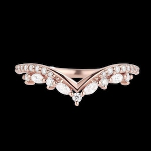 Peut inclure: Bague en or rose avec un motif en chevrons. La bague est ornée de petites pierres blanches rondes et en forme de marquise. Les pierres sont serties sur le dessus de la bague, créant un aspect étincelant et élégant.
