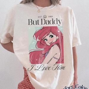 K&ouml;nnte beinhalten: Elfenbeinfarbenes T-Shirt mit einer Comicfigur mit rosa Haaren und dem Text "But Daddy I Love Him". Das Shirt hat auch den Text "EST 1989" und "Comfort Colors Ivory."