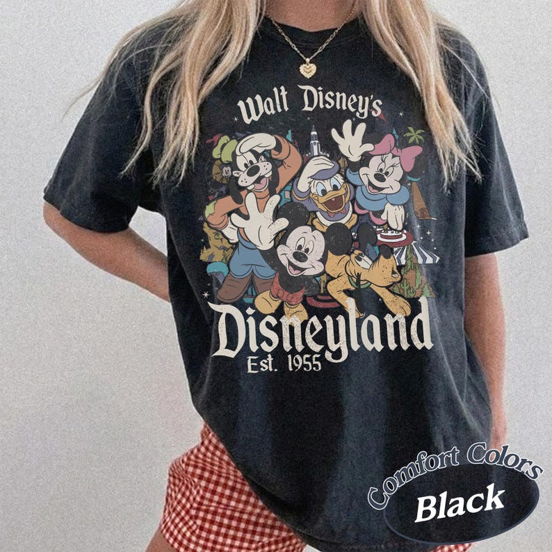 May include: Black t-shirt featuring a vintage Disneyland graphic with Mickey Mouse, Minnie Mouse, Donald Duck, Goofy, and Pluto. The shirt has the text "Walt Disney's Disneyland Est. 1955" and "Comfort Colors Black".