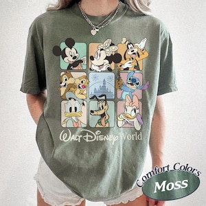May include: Olive green t-shirt featuring a grid of Disney characters including Mickey Mouse, Minnie Mouse, Goofy, Chip and Dale, Donald Duck, Pluto, Stitch, and Daisy Duck. The words "Walt Disney World" are printed below the grid.