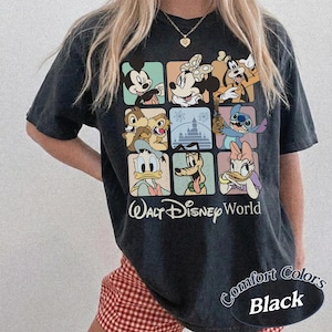 May include: Black t-shirt featuring a grid of Disney characters including Mickey Mouse, Minnie Mouse, and Donald Duck. The words "Walt Disney World" are printed below the grid. The shirt also has the words "Comfort Colors Black".