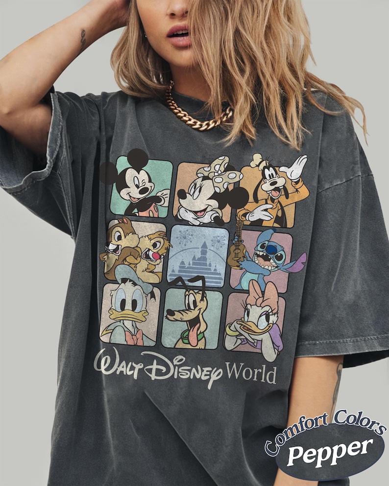 May include: Dark gray t-shirt featuring a grid of Disney characters including Mickey Mouse, Minnie Mouse, Goofy, Chip and Dale, Donald Duck, Pluto, Stitch, and Daisy Duck. The words "Walt Disney World" are printed below the grid. The shirt is labeled "Comfort Colors Pepper".