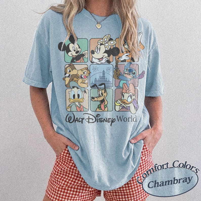 May include: Light blue t-shirt featuring a grid of Disney characters including Mickey Mouse, Minnie Mouse, Chip and Dale, Stitch, Donald Duck, Pluto, and Daisy Duck. The words "Walt Disney World" are printed below the grid. The shirt is labeled "Comfort Colors Chambray".