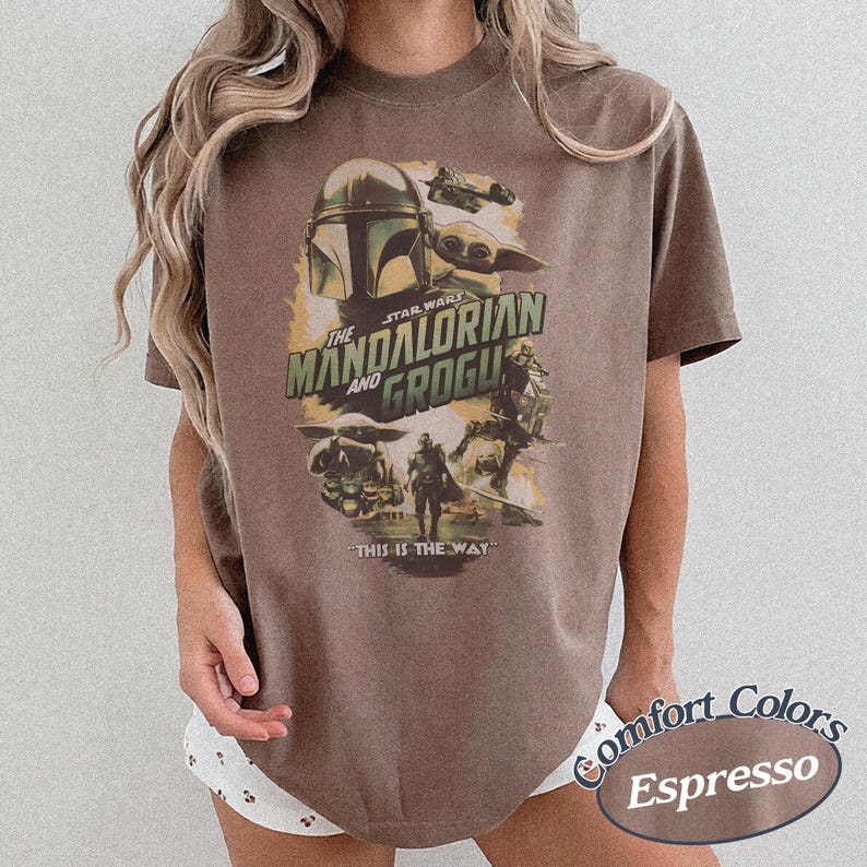 Może przedstawiać: Koszulka w kolorze espresso z grafiką z serialu The Mandalorian. Projekt zawiera napis "The Mandalorian and Grogu" ze zdjęciami postaci i frazą "This is the Way."