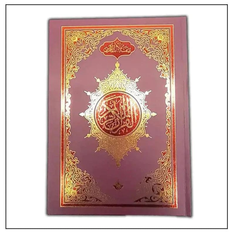 May include: A hardcover book with a mauve cover and ornate gold foil detailing. The cover features Arabic calligraphy within a central medallion and decorative borders. The book's design is symmetrical and traditional.
