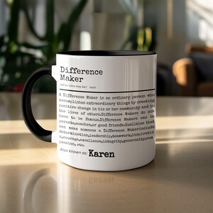 Peut inclure: Mug en céramique blanche avec une anse et un bord noirs. La tasse présente le texte "Difference Maker" et une définition, avec la phrase "Also known as: Karen."