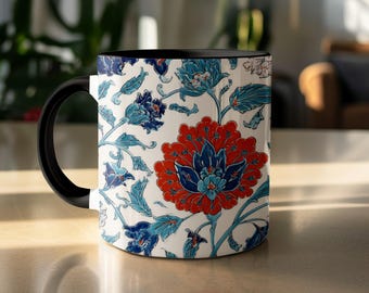 May include: A ceramic mug with a black handle and interior. The exterior features a floral design in red, blue, and turquoise against a white background. The design includes large flowers and intricate leaf patterns.