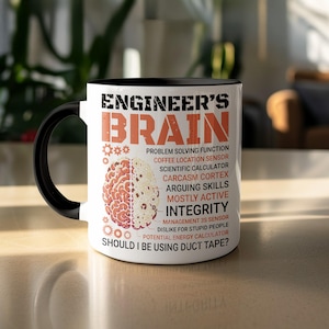 May include: A white ceramic mug with a black handle and rim. The mug features the text "ENGINEER'S BRAIN" in orange, along with a diagram of a brain and a list of engineer-related attributes. The question "SHOULD I BE USING DUCT TAPE?" is also printed on the mug.