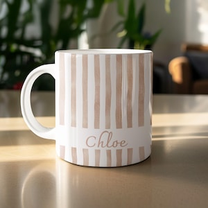 Puede incluir: Taza de cerámica blanca con rayas verticales color melocotón y el nombre "Chloe" en escritura cursiva. La taza tiene un asa curvada. Diseño sencillo y elegante, para bebidas calientes.