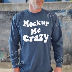 May include: A blue long-sleeve shirt with the text "Mockup Me Crazy" in white, retro-style lettering.