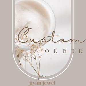 Puede incluir: Un recipiente circular lleno de una crema de color beige claro, acentuado por delicadas flores blancas de paniculata. La imagen presenta el texto Custom ORDER y jiyan jewel en una fuente marrón claro, enmarcado por un borde rectangular redondeado.