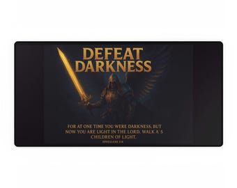 May include: A rectangular black desk mat with the gold text "DEFEAT DARKNESS" above an illustration of an angel with a glowing sword. The mat also features a Bible verse in white text.