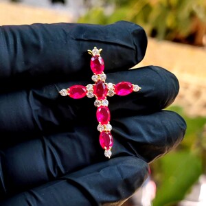 Colgante de cruz con rubí rojo sintético de talla ovalada y acabado en oro amarillo de 14 quilates (plata de ley 925).