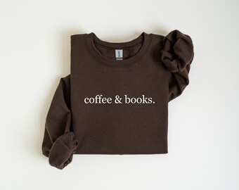 May include: A dark brown sweatshirt with the words "coffee & books." printed in white. The long-sleeved crew neck top is made of a soft material and is displayed on a white background.