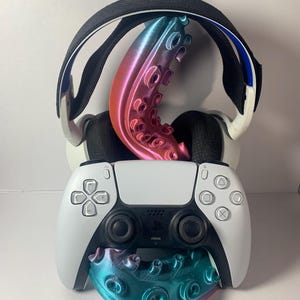 Peut inclure: Une manette et un casque PlayStation 5 blancs sont présentés avec un tentacule et une base de poulpe imprimés en 3D. Le tentacule est de couleur dégradée, passant du rose au bleu. La base est turquoise et violette.