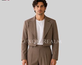 May include: A cropped taupe blazer with a single button closure, worn over a plain white t-shirt and matching high-waisted taupe trousers. The blazer features wide lapels and long sleeves. The text LUXON REALM is visible across the center.