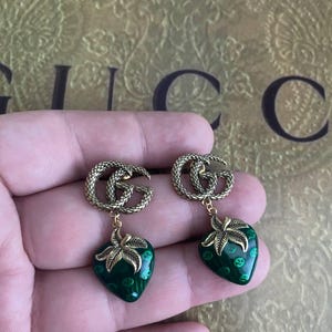 Pendientes colgantes de fresa con esmalte verde y logotipo GG dorado de Gucci
