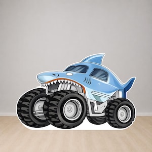 Op de afbeelding: Een lichtblauwe monstertruck met een haai-ontwerp. De truck heeft grote zwarte banden, een haaienvin en een grijnzende bek. De afbeelding is een cartoonillustratie.