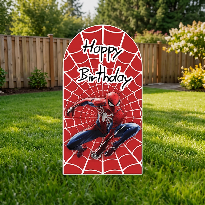 May include: An arched sign featuring a red background with a white spiderweb pattern. The text "Happy Birthday" is printed in black at the top. A graphic of a red and blue costumed character in a crouching pose is centered on the sign.