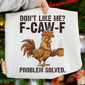 May include: White graphic tee with a cartoon rooster holding a coffee mug. The text says "DON'T LIKE ME? F-CAW-F PROBLEM SOLVED." The rooster is brown, yellow, and red, with steam rising from the mug.