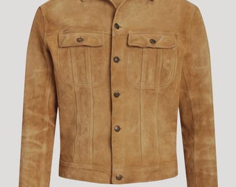 May include: A tan suede jacket with a classic design. The jacket features two chest pockets, two side pockets, and a button-up front. The collar is a traditional spread collar. The jacket is a neutral color and appears to be made of soft suede.