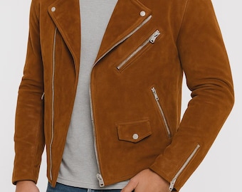 May include: A brown suede jacket with a classic biker style. The jacket features a notched collar, multiple zippered pockets, and silver hardware. The model is wearing a gray t-shirt and blue jeans. The jacket's length is approximately 25 inches.