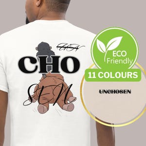 Könnte beinhalten: Weißes T-Shirt mit einer Grafik mit den schwarzen Wörtern "CHO SEM" und einer Cartoon-Illustration. Das Shirt hat auch den Text "UNCHOOSEN" und ein "Eco Friendly"-Logo mit "11 FARBEN".