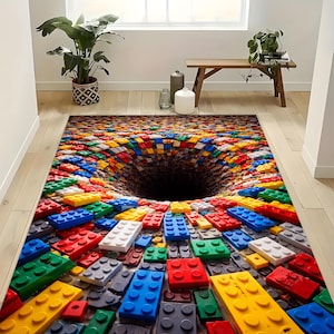 May include: A rectangular rug with a 3D optical illusion design. The rug features a colorful pattern of toy building blocks in various colors, including red, blue, yellow, and green, creating a visual vortex effect.