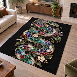 May include: A rectangular area rug featuring a black background with a large, central snake illustration. The snake is composed of multicoloured, jewel-toned scales in shades of red, blue, green, and white, surrounded by white and purple floral accents.