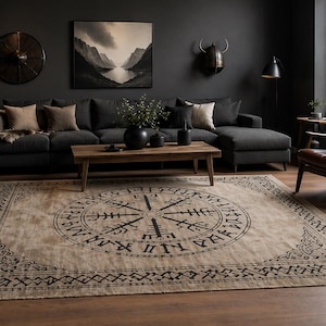 Könnte beinhalten: Beiger Teppich mit großem schwarzem Kompassrosen-Design in einem Wohnzimmer. Der Teppich hat einen geometrischen Rand und befindet sich vor einem dunkelgrauen Ecksofa und einem Holztisch. Der Raum hat dunkle Wände und einen Ledersessel.