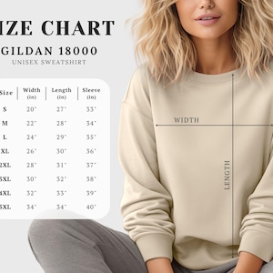 Puede incluir: Una tabla de tallas para una sudadera unisex Gildan 18000. La tabla muestra las medidas de ancho, largo y largo de manga en pulgadas para las tallas S a 5XL. La modelo lleva una sudadera beige.