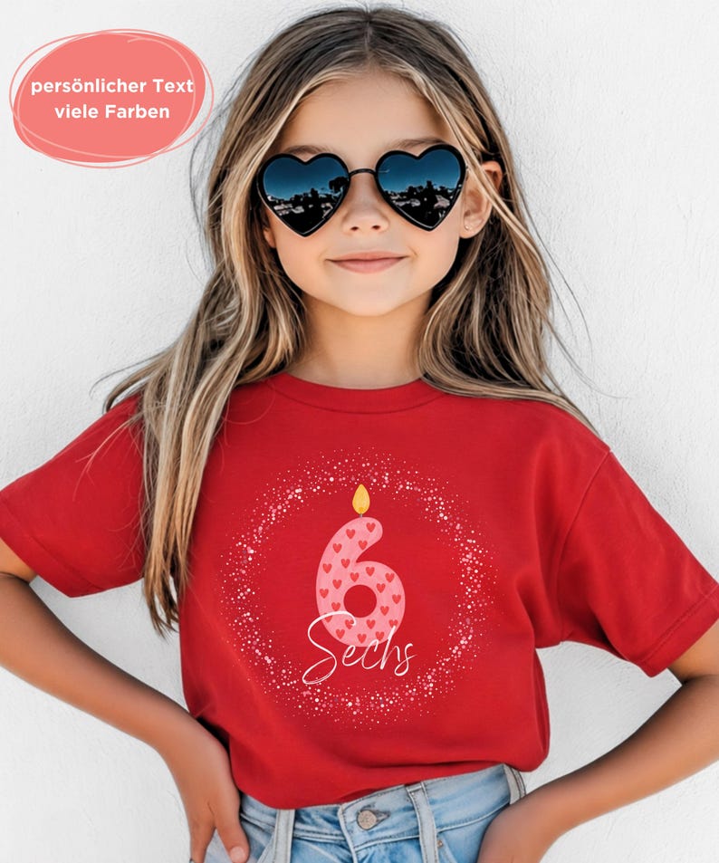 K&ouml;nnte beinhalten: Ein rotes T-Shirt mit einem Geburtstagskerzen-Design, das die Zahl 6 und das Wort "Sechs" zeigt. Die Zahl 6 ist mit rosa Herzen verziert. Das T-Shirt wird von einer Person getragen, die herzf&ouml;rmige Sonnenbrillen tr&auml;gt. Der Text auf dem Bild lautet "personlicher Text viele Farben".