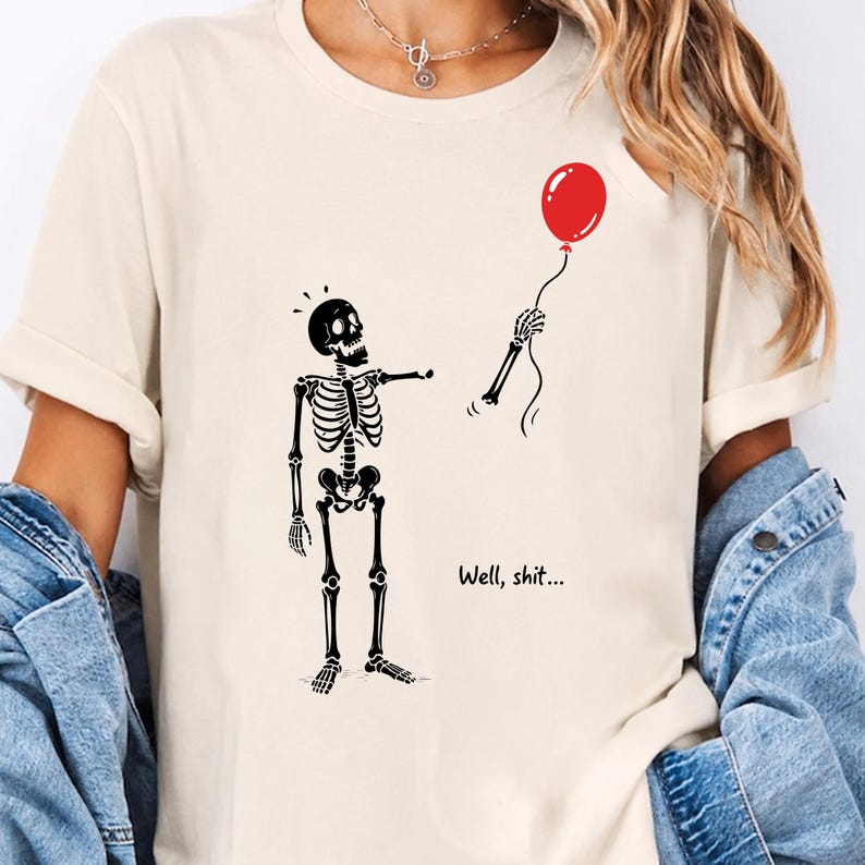 Cream shirt mockup with Well Shit funny skeleton, red balloon and dark humor Halloween PNG SVG design.