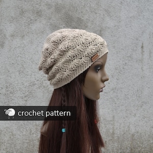 May include: A beige crochet beanie with a textured pattern. The beanie is slouchy and has a small brown label on the side.